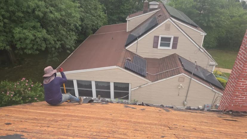 Roofing contractor installing asphalt shingles on a residential home roof